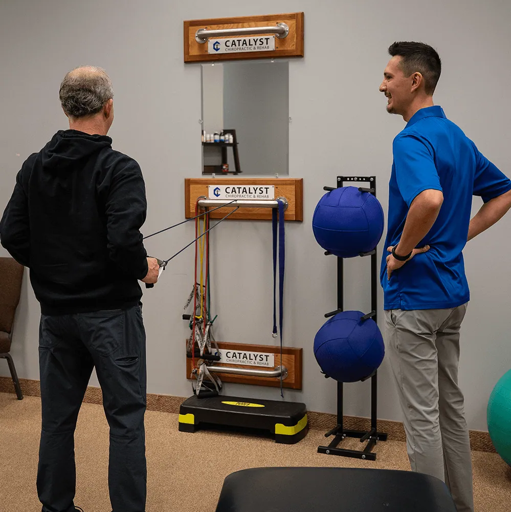 Patient doing rehab exercises with coaching at Catalyst Chiropractic & Rehab