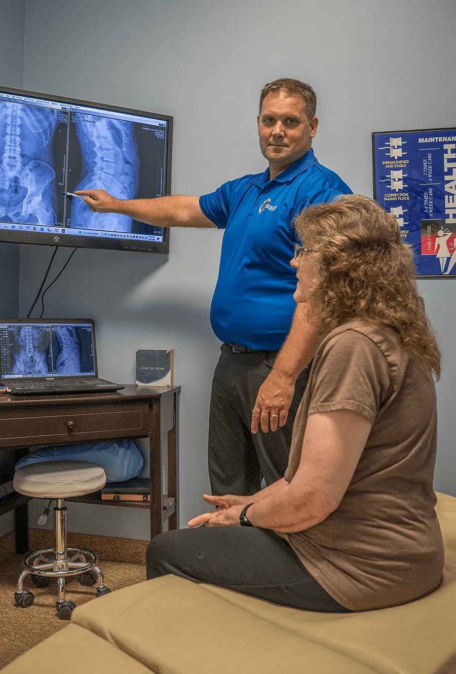 Chiropractor reviewing spine x-rays with a patient