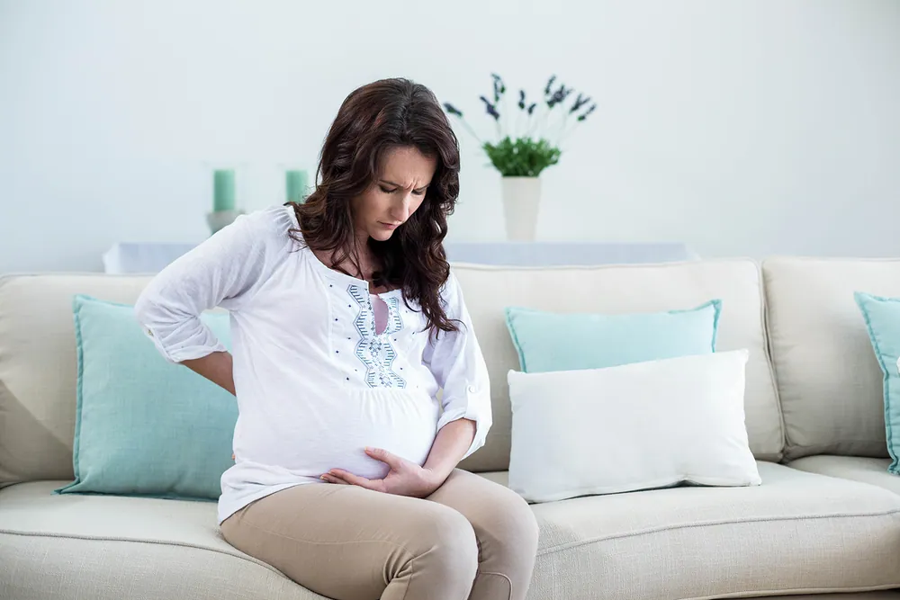 pregnant woman sitting in couch feel pain on her back