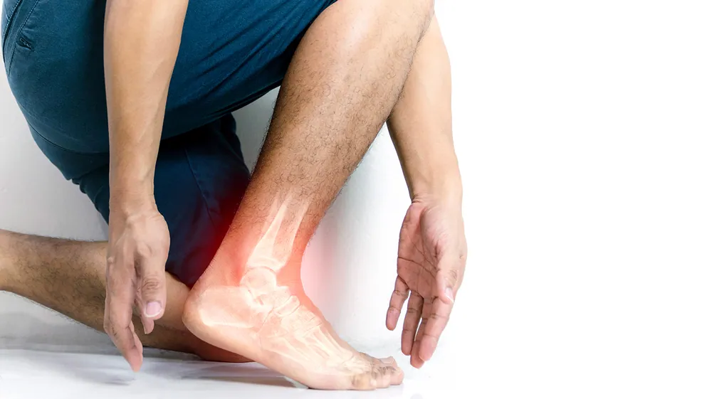 hand touching ankle due to leg pain cramps