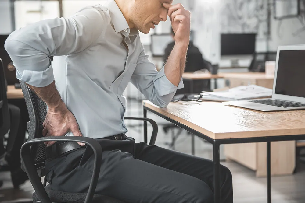 man holding his back due to pinched nerve pain