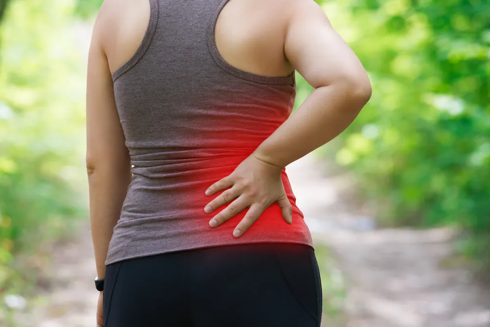 woman holding her lower back due to sciatica pain