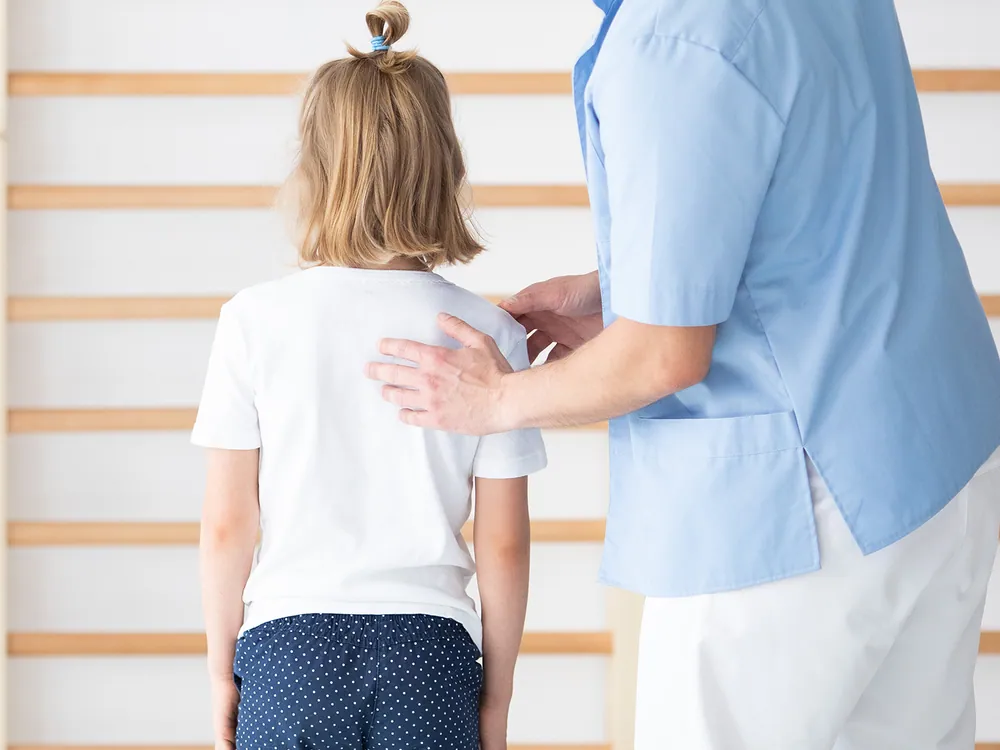 doctor checking kid scoliosis condition